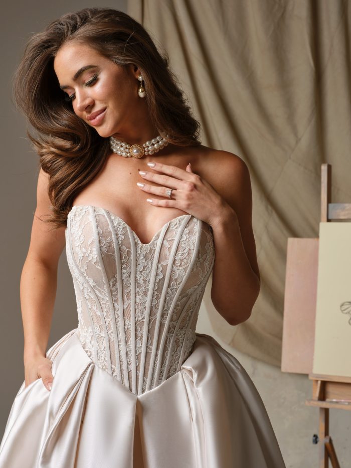 Close-up of the Ashland wedding dress by Maggie Sottero showing a sheer organza-lined Chantilly lace bodice with exposed boning and a strapless V-neckline