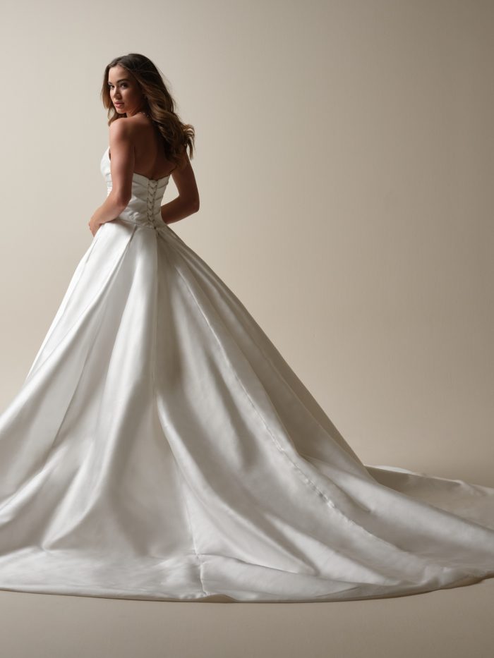 Back view of strapless Mikado ball gown wedding dress featuring lace-up corset closure and dramatic chapel-length train for a timeless bridal look