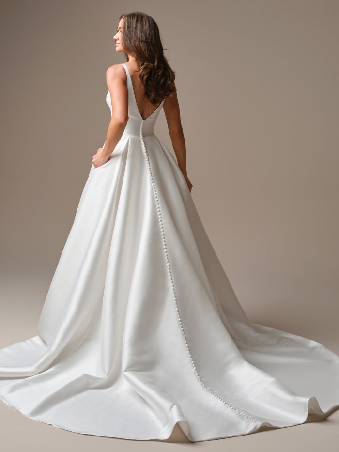 Back view of Galina by Maggie Sottero — classic satin A-line gown with a deep V-back, full skirt, and fabric-covered buttons trailing to a chapel-length train.