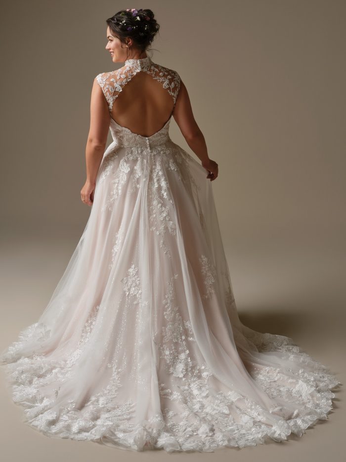 Cody A-line wedding dress with a high illusion lace back, floral lace details, and a flowing lace trimmed train captured in a soft studio backdrop.
