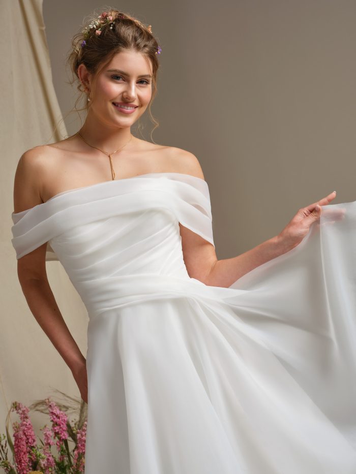 Close-up of Rebecca Ingram Dezi wedding dress featuring soft off-the-shoulder neckline and flowing chiffon fabric