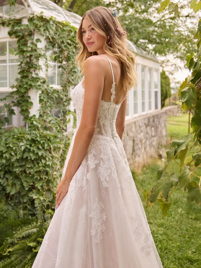Back view of Esmeralda by Rebecca Ingram, featuring a lace A-line silhouette with beaded straps, illusion back, and chapel-length train.