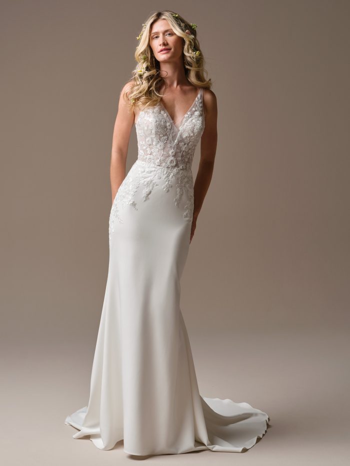 Bride wearing the Holly sheath wedding dress with a deep V-neckline, illusion lace bodice, delicate tank straps, and a sleek minimalist silhouette.