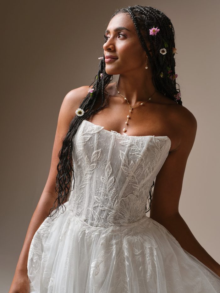 Close-up of Lisa by Rebecca Ingram featuring a strapless lace bodice with botanical embroidery and soft tulle skirt layers