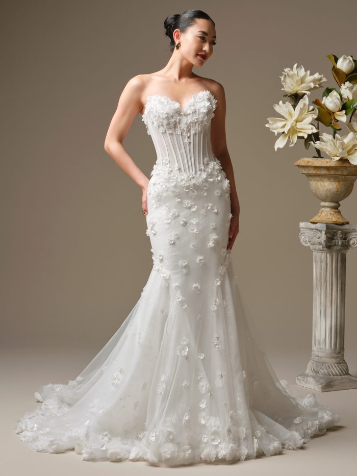 Bride wearing the Akari fit-and-flare wedding dress by Sottero and Midgley, featuring a strapless corset bodice with dimensional floral appliqués and a softly flared tulle skirt with a floral-trimmed train.