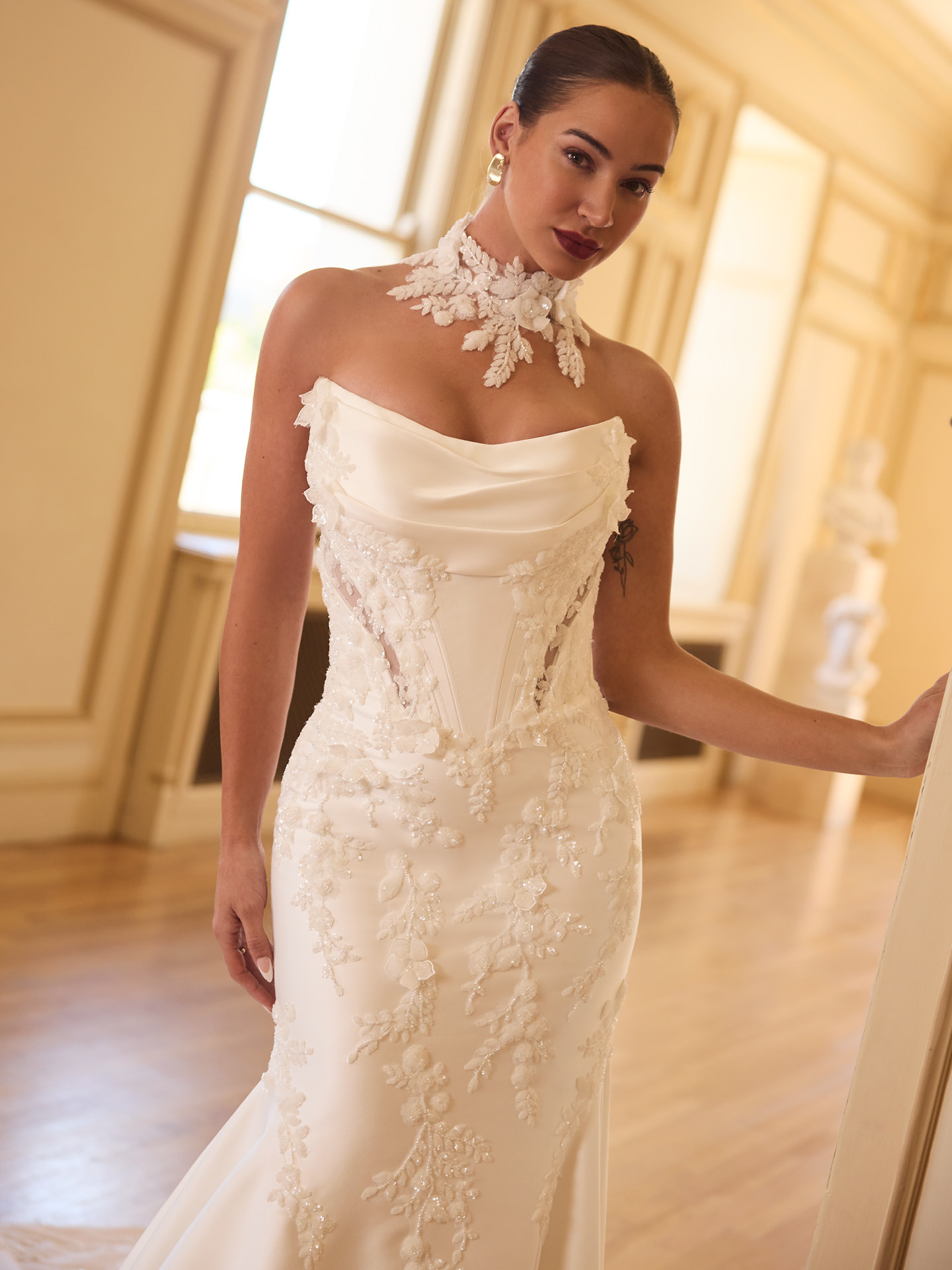 Burke beaded lace fit-and-flare wedding dress with draped strapless neckline, exposed corset detail, and intricate floral sequin appliqués.