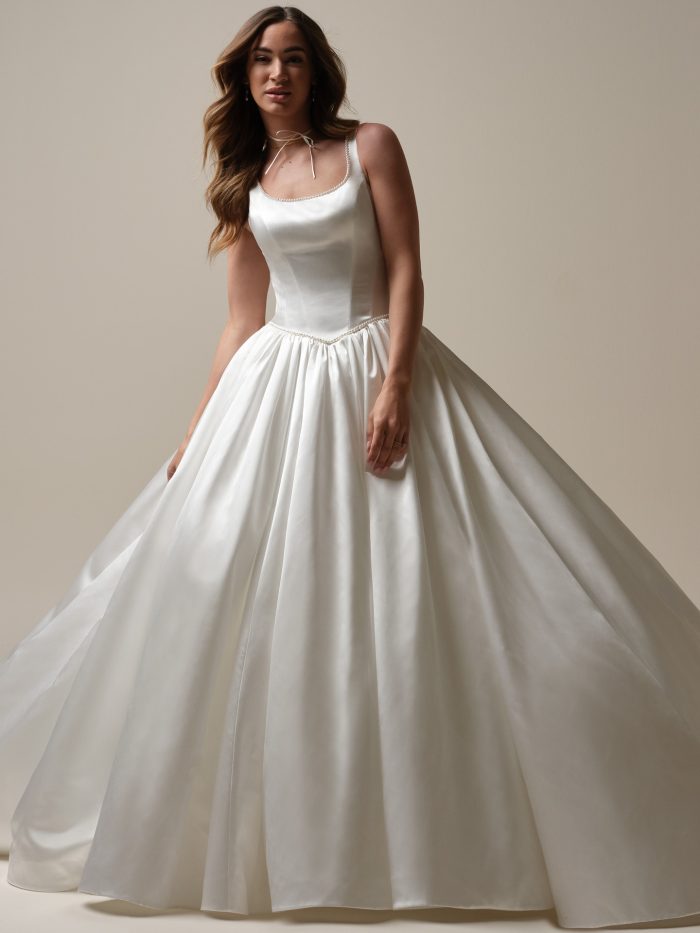 Diaz by Sottero & Midgley satin ballgown wedding dress with a basque waist, scoop neckline, pearl-trimmed waistline, and full flowing skirt