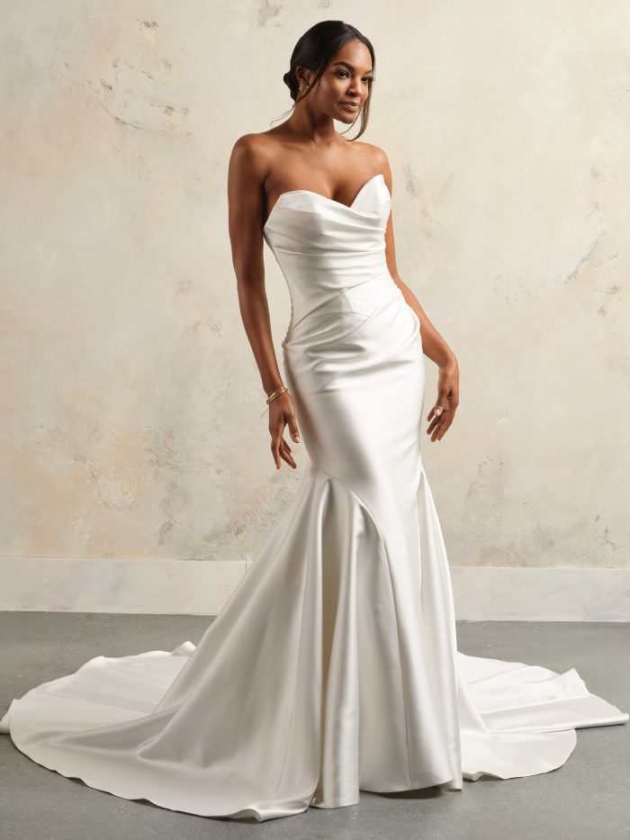 Bride wearing the Giselle mermaid wedding dress featuring sleek satin fabric, a strapless draped bodice, and a fitted silhouette that flares into a full train for a timeless, elegant look.