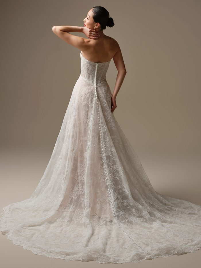 Back view of Granger by Sottero and Midgley, featuring a strapless lace A-line silhouette with covered buttons and chapel-length train.