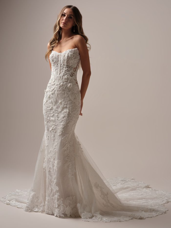 Bride wearing the Halle fit and flare wedding dress featuring a strapless beaded lace bodice, illusion side details, and a dramatic lace train.