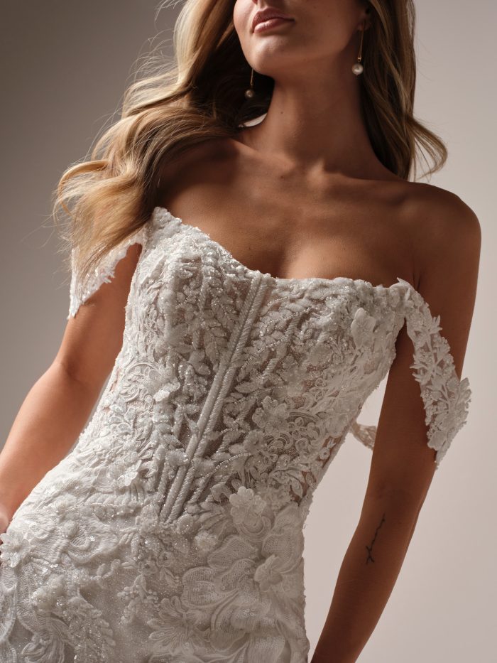 Close-up of the Sottero and Midgley Halle wedding dress highlighting the beaded lace bodice, illusion details, and detachable off-the-shoulder straps for a luxe textured bridal look.